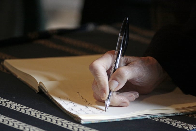 Person Writing on a Notebook